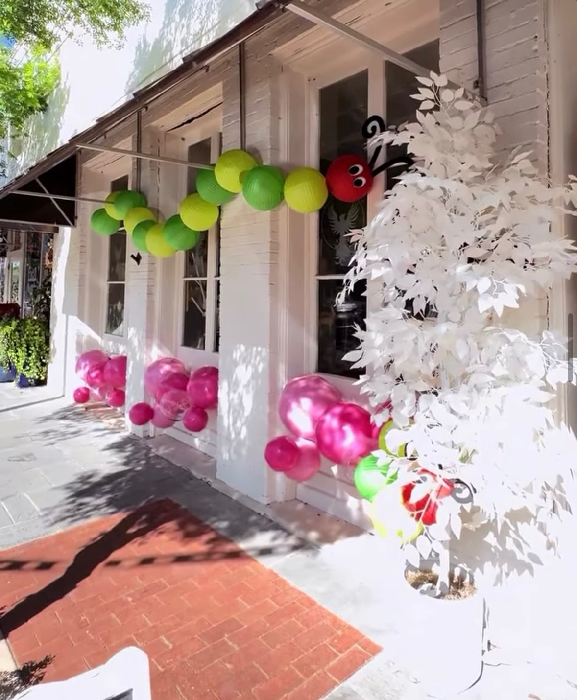 Festive storefront with caterpillar balloon decor at Phoenix Rising